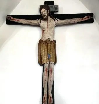 Enghausen Cross with a carved wooden crucifix of Jesus, showing a golden-brown loincloth and a plaque above the head.