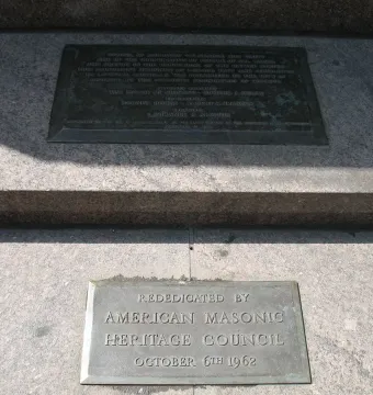Heald Square Monument base plaques embedded in a granite stone base, including a rededication plaque.