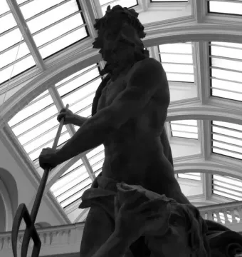 Neptune and Triton sculpture seen from below, with Neptune holding a trident and Triton blowing a conch shell beneath a glass ceiling.