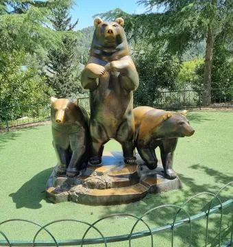 Group of Bears sculpture with a tall bear flanked by two smaller bears on a stepped base.
