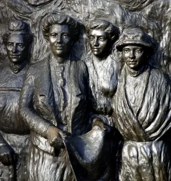 Bronze relief of six women on the Kate Sheppard National Memorial, with the central figure holding a rolled document.
