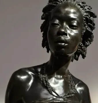The Nubian Woman bronze bust with an elaborate coiled hairstyle and layered necklace.