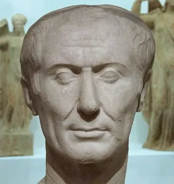 Tusculum portrait of Julius Caesar, a weathered marble bust with a receding hairline and lined face.