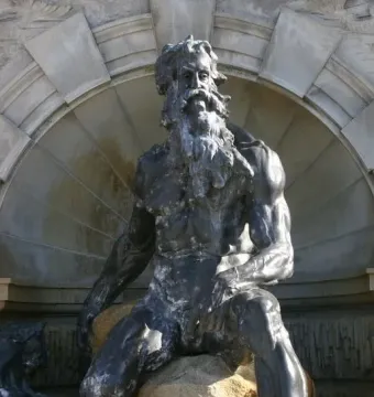 Court of Neptune Fountain sculpture of a bearded Neptune seated on rocks before an ornate stone alcove