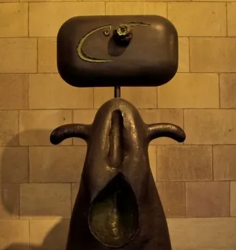 Joan Miró’s Mujer, an abstract dark metal sculpture with a rounded head-like form and an oval opening in the lower body.