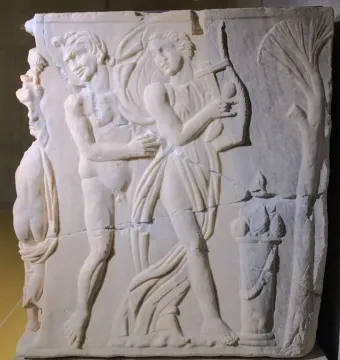 Roman marble relief from the Sarcophagus of the Triumph of Bacchus showing a draped figure playing a lyre beside a nude satyr-like male figure and a small altar or pedestal with fruit.