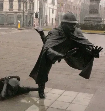 Vaartkapoen bronze sculpture showing a man emerging from a manhole and grabbing a startled policeman\'s ankle.