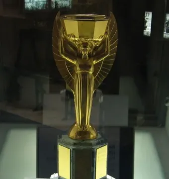 Jules Rimet Trophy replica showing a winged female figure holding a cup above her head on a dark base.