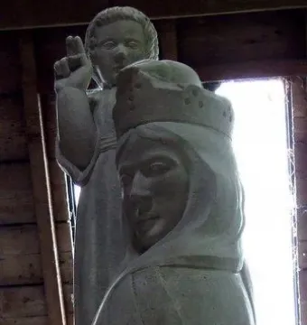 Our Lady of the Isles stone statue of a crowned woman in a hooded cloak with a child figure behind her