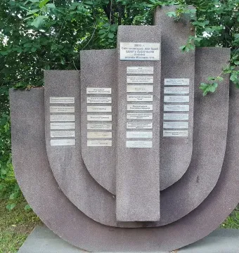 The Pit memorial with textured stone slabs and small plaques set in a grassy area.