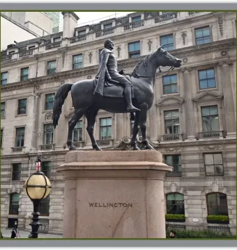 The Duke of Wellington equestrian monument on a granite pedestal in front of a stone building.
