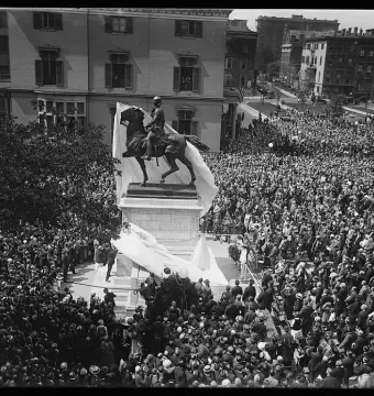 Crowd gathered around the Lafayette Monument as a white sheet is being removed from the equestrian statue.