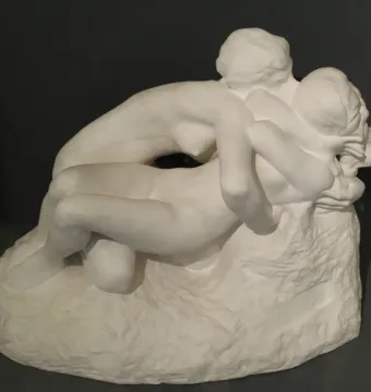 Rodin\'s Metamorphoses sculpture showing two intertwined nude figures on a textured base.