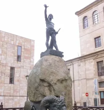 Monument to Viriato, a dark metal warrior sculpture on a large boulder behind an iron fence.