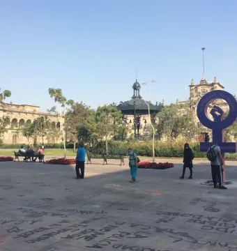 Antimonumenta, a large purple feminist symbol with a raised fist, stands in a public plaza covered in graffiti-like markings.