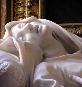 Close-up of Bernini’s Ecstasy of Blessed Ludovica Albertoni, showing the recumbent marble figure’s face, drapery, and carved pillow.