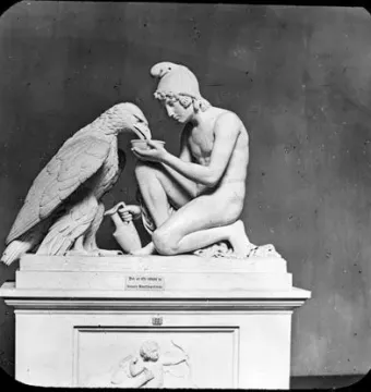 Ganymede with Jupiter’s eagle, a white sculpture of a kneeling nude youth offering a bowl to a large eagle on a pedestal.