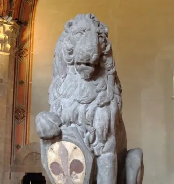 Marzocco, a seated stone lion with its paw on a shield decorated with a fleur-de-lis.