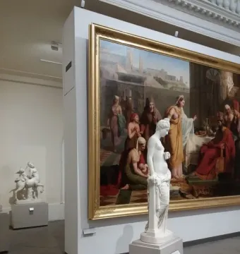 Pandora, a white marble female statue leaning against a pillar with drapery around her lower body