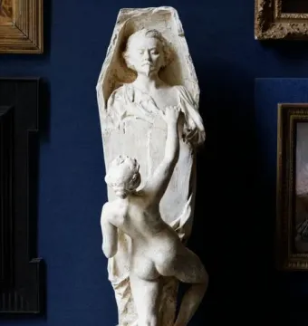 La Gloire sculpture showing a nude female figure pulling boards away from a coffin-shaped structure, revealing a male bust inside.