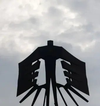 Monument to the Azoreans shown as a dark abstract sculpture with broad horizontal panels and radiating base elements.