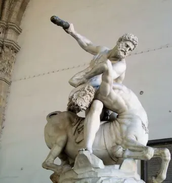 Heracles and Nessus marble sculpture showing a muscular man wrestling a centaur with a club raised overhead