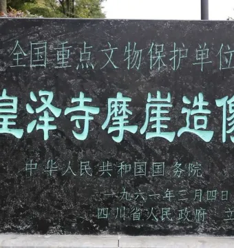 Stone monument at Huangze Monastery Rock Sculptures with bright teal Chinese characters carved into the surface