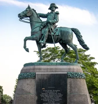 Israel Putnam Monument with a bronze equestrian statue of a man in military uniform and tricorn hat on a tall stone pedestal.