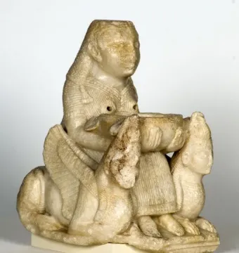 Lady of Galera seated stone figurine holding a bowl, flanked by winged creatures