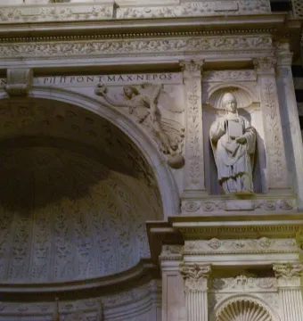 White marble statue of Saint Gregory in a decorative niche, holding a book and stylus and wearing a pointed tiara.