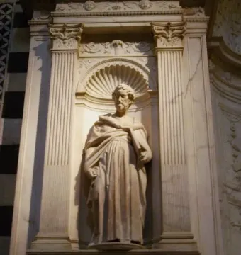 Marble statue of Saint Peter in a carved niche, holding an object in his left hand.