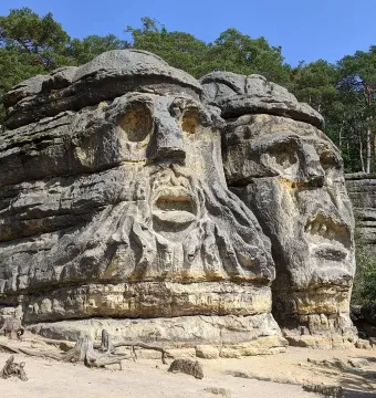 Devil\'s Heads carved into sandstone rock formations beneath a clear blue sky.