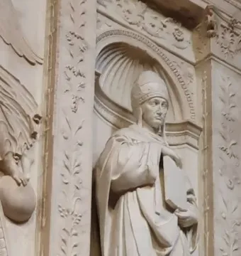 Saint Gregory stone sculpture of a robed figure holding a closed book in a carved niche with floral columns.