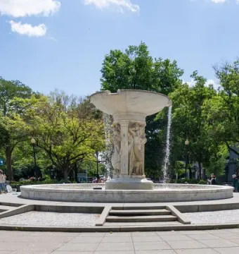 Dupont Circle Fountain with sculpted figures supporting the upper basin in a tree-lined plaza