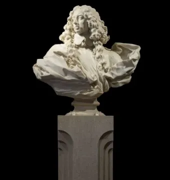 Marble bust of Francesco I d\'Este with curly hair, draped clothing, and an ornate pedestal against a black background.