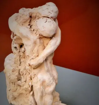 Sakuntala sculpture showing two intertwined figures in an embrace, one leaning over a kneeling figure.