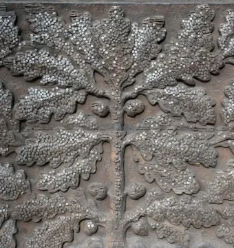 Wehrmann in Eisen surface with carved oak leaves and densely hammered metal nails