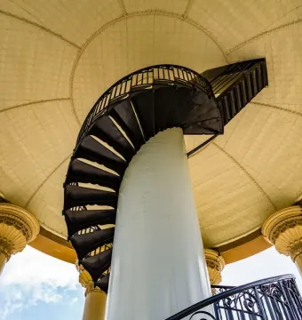Spiral staircase inside the Hermann Heights Monument leading up to a patterned domed ceiling.