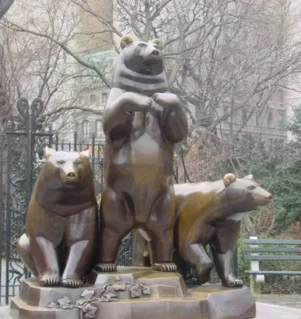Group of Bears sculpture with three bear figures on a decorative base in a park.