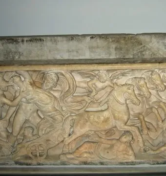 Relief on the Proserpina Sarcophagus showing a mythological kidnapping scene with a woman seized by a man, a chariot, and winged figures.
