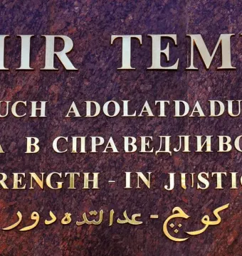 Close-up of the Amir Temur inscription with gold lettering on a reddish-brown stone surface.