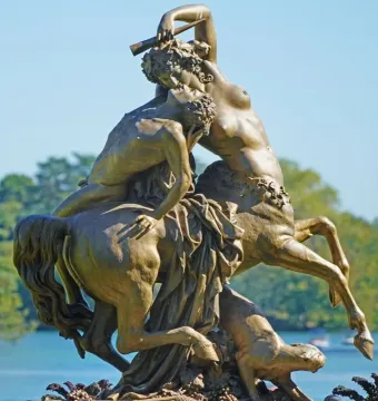 Centauress and Faun sculpture showing a female centaur rearing while kissing a man on her back.