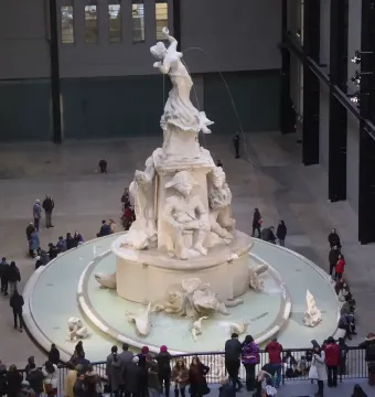 Fons Americanus fountain in the Turbine Hall at Tate Modern, surrounded by visitors.