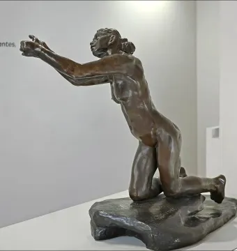 The Implorer bronze sculpture of a nude woman kneeling with outstretched arms.