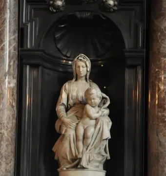 Madonna of Bruges marble sculpture of a seated woman holding a nude infant in an ornate niche