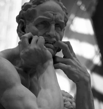Stone sculpture of Ugolino and His Sons showing a man in intense anguish with his hands gripping his mouth.