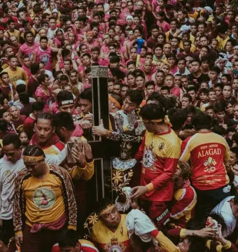 Black Nazarene statue carried through a tightly packed crowd of devotees reaching out to touch it