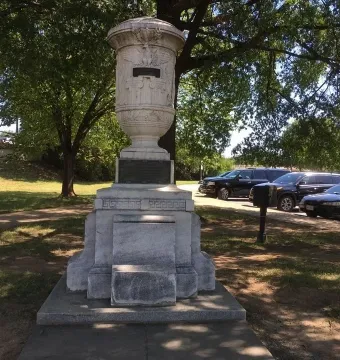 The Cuban American Friendship Urn, a stone urn monument on a stepped pedestal in a grassy park.