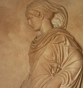 Gradiva relief showing a female figure in profile with flowing drapery and her head tilted downward.
