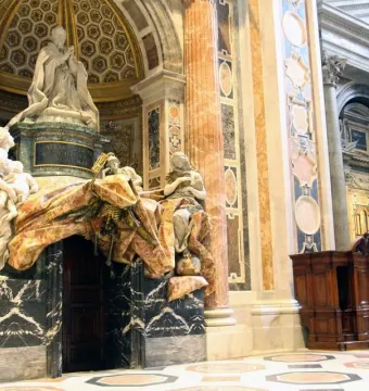 Tomb of Pope Alexander VII with a praying figure, white marble allegorical statues, and a dramatic draped canopy above a doorway.